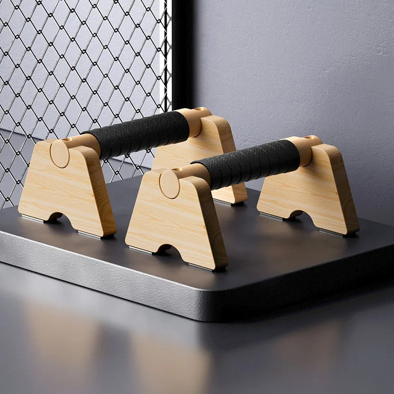 Wooden parallettes with black grip pads on two parallel bars and curved wooden bases