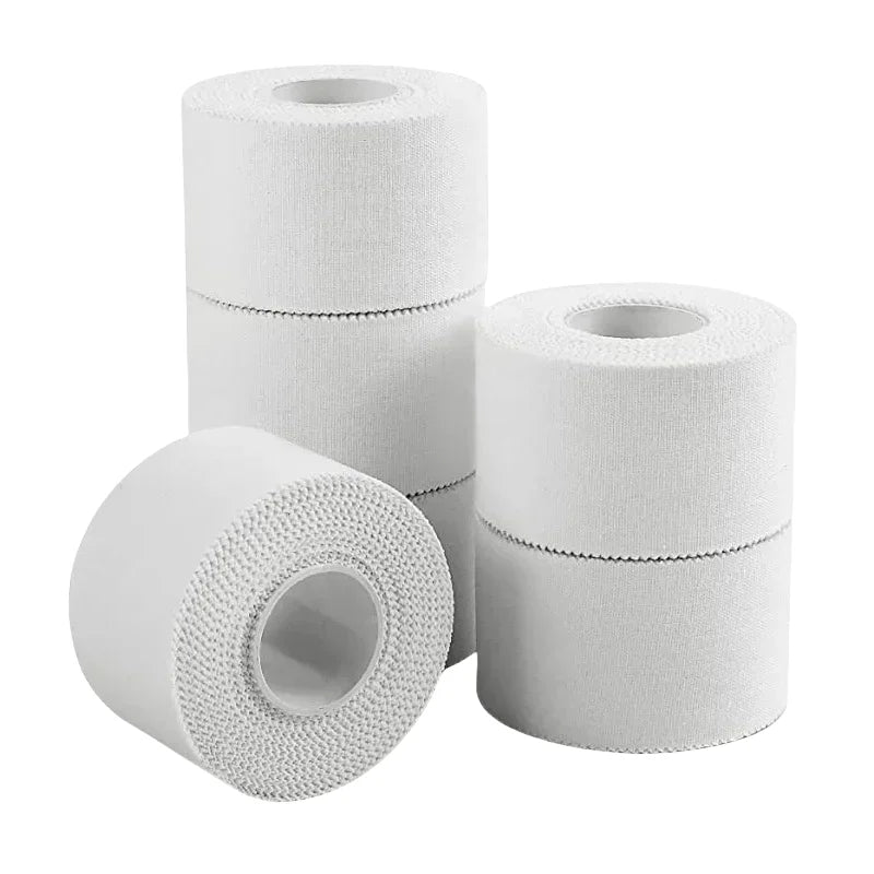 Three white athletic trainer tape rolls, single roll foreground and two stacked back